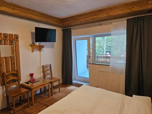 CumpănaにあるCasa Mioritaのベッドと机と窓のある寝室