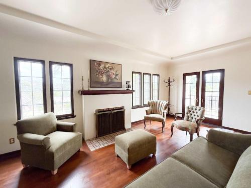 The Vintage La Mesa Tudor في Spring Valley: غرفة معيشة مع أريكة وكراسي ومدفأة