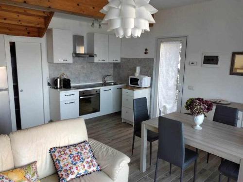 a kitchen and living room with a couch and a table at Una terrazza sul lago in Argegno
