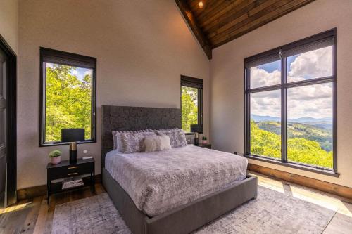 a bedroom with a large bed and large windows at Bucks and Bunnies at Eagles Nest in Elk Park