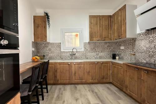 a kitchen with wooden cabinets and a counter top at Habitación L'Elefant en Casa Camí de les Aigües Monistrol de Montserrat in Monistrol