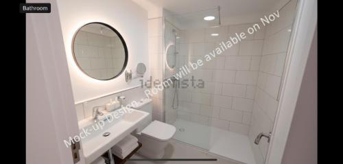 um banheiro branco com uma pia e um espelho em Coco Canaria em Corralejo