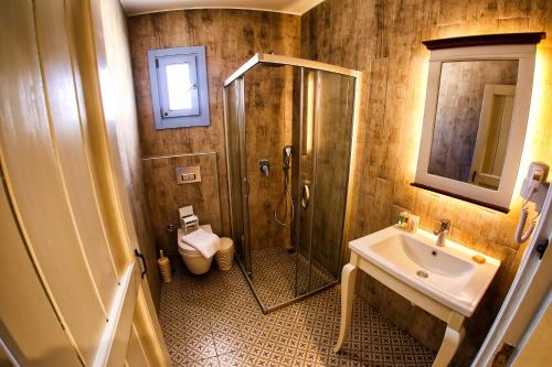 a bathroom with a shower and a sink and a toilet at Villa Fanti in Çeşme