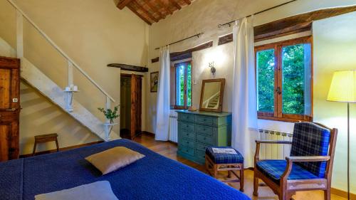Un dormitorio con una cama azul y una silla. en Luce tra i Saggi 8 by Marche Holiday Villas, en Montemaggiore al Metauro