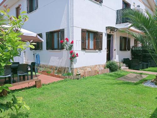 a house with a lawn in front of it at Chalet adosado entre playas in Argoños