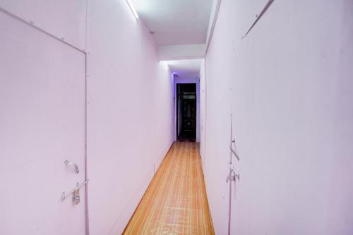 a hallway with white doors and a wooden floor at SPOT ON Prayaj In Hotel & Restaurant in Prayagraj