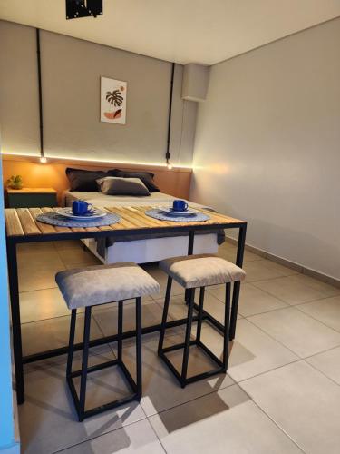 un tavolo da pranzo con 2 sgabelli in una stanza di Studio & suites Patricia Tennis ad Abelardo Luz
