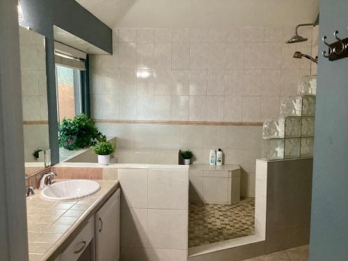a bathroom with a sink and a bath tub at Maple House w-Private Jacuzzi Near IAH in Humble
