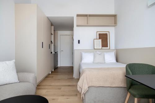 a small bedroom with a bed and a couch at Calido Las Tablas in Madrid