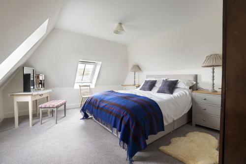 a bedroom with a bed and a desk and a chair at The Bothy at Redheugh in Newcastleton