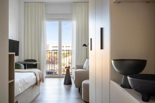 a hotel room with a bed and a balcony at Calido Las Tablas in Madrid