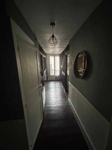 een donkere gang met een deur en een spiegel bij WAROUX - Appartement Rennes 6P in Rennes