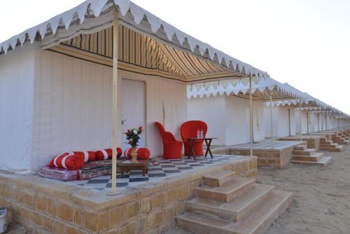 a house with red chairs and a table on a patio at Kesariya Heritage Resorts in Jaisalmer