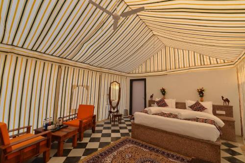 a bedroom with a bed and a ceiling fan at Kesariya Heritage Resorts in Jaisalmer