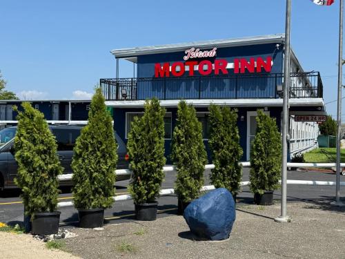 a group of trees in front of a motor inn at Island Motor Inn in Island Park