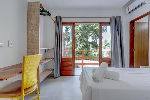 Un dormitorio con una cama y un escritorio y una ventana. en HS Residence 1, en Itacaré
