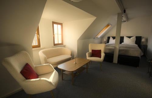 a bedroom with a bed and two chairs and a table at Fewo Charlotte in Weimar