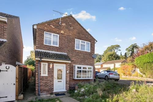 a brick house with a white door and a car at 5-Bed House with Garden Near Warner Bros Studios in Hemel Hempstead