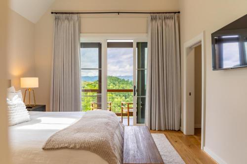 a bedroom with a bed and a large window at Calico Haven At Blue Ridge Mountain Club in Boone