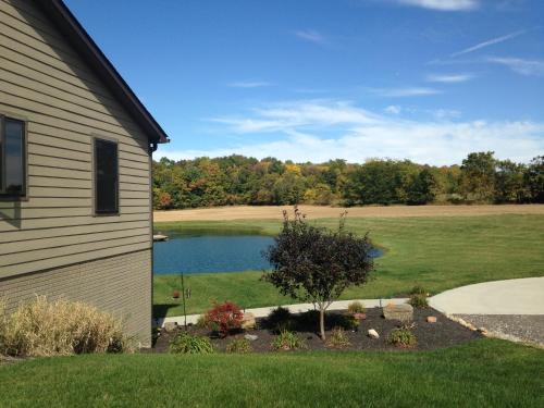 a house with a pond next to a house at Maple Brook Memories in Amanda