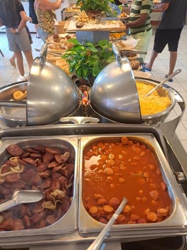 a buffet with many different types of food in trays at Lagoa Quente Hotel - Flat com Café da Manhã e Acesso ao Parque Aquático in Caldas Novas