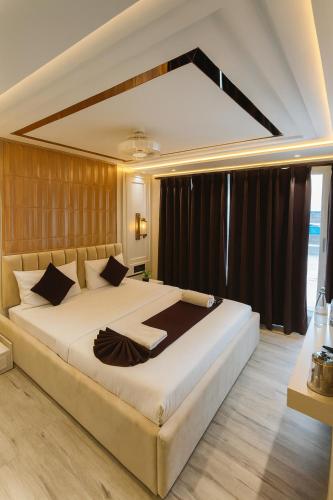 a bedroom with a large white bed with black curtains at The Vacation Villa Agra A Boutique Hotel Near Taj Mahal in Agra