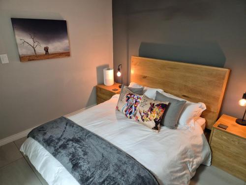 a bedroom with a large white bed with pillows at Wine Not Relax in Yzerfontein