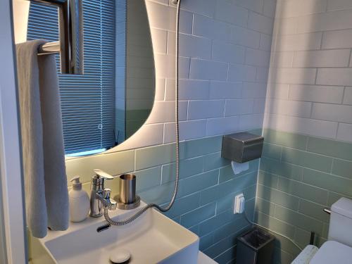 un baño con lavabo y espejo en Stay D, en Goseong