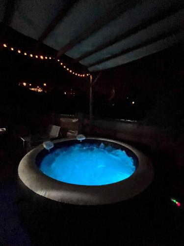 a large blue bath tub in a dark room at Au coin de la cheminée in Saint-Leu