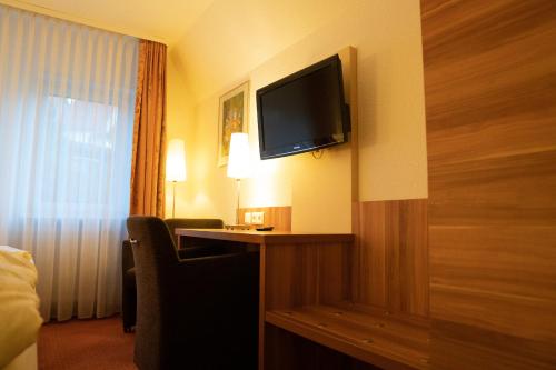 a hotel room with a television on a wall at Hotel Jägerhof in Bad Hersfeld