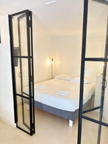 um pequeno quarto com uma cama e um espelho em Le Cocon de Vence - Piscine Free Parking em Vence