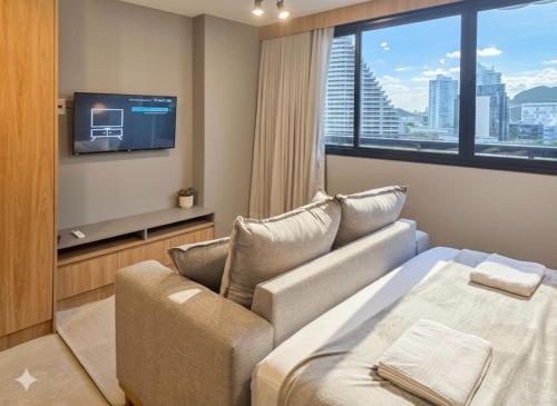 a hotel room with a bed and a tv at A7 Vix by Housi – studios e apartamentos modernos em Vitória in Guajuru