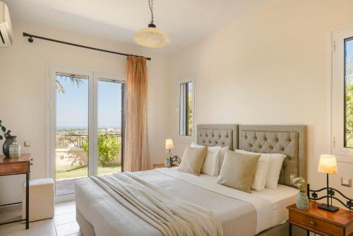 a white bedroom with a large bed with windows at Dina by Vintage Travel in Kaligata