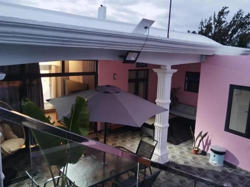 a purple house with an umbrella on a balcony at Charming Villa with Pool in Souillac in Souillac