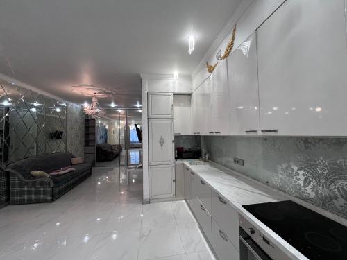 a kitchen with white cabinets and a living room at на ПЛЯЖЕ Отрада, Французский бульвар Просторный 2 комн Luxury апартамент , центр ЖК Париж in Odesa