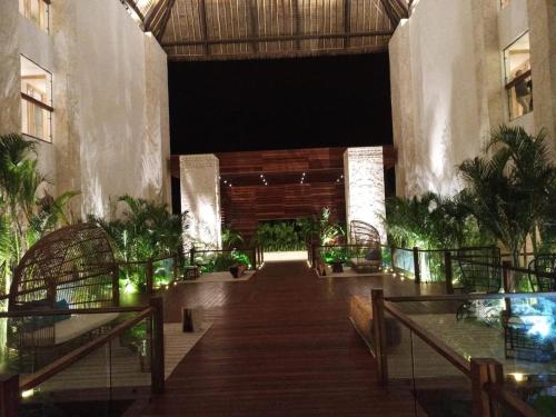 a hallway in a building with trees and lights at Hotel Mundo Maya Nuevo Uxmal in Santa Elena