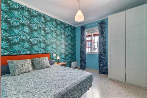 a bedroom with a bed and a blue wall at El Rincón de Doñana in Villamanrique de la Condesa