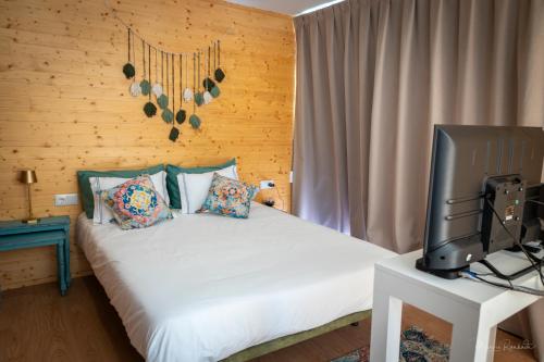 a bedroom with a bed with a tv on a table at Bungalow da Romy in Vila Praia de Âncora