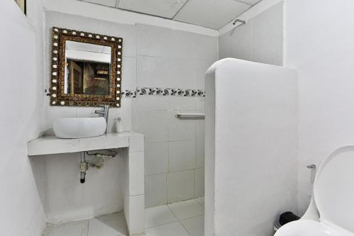 une salle de bain blanche avec un lavabo et un miroir dans l'établissement Taironaka Eco Hotel, à Don Diego