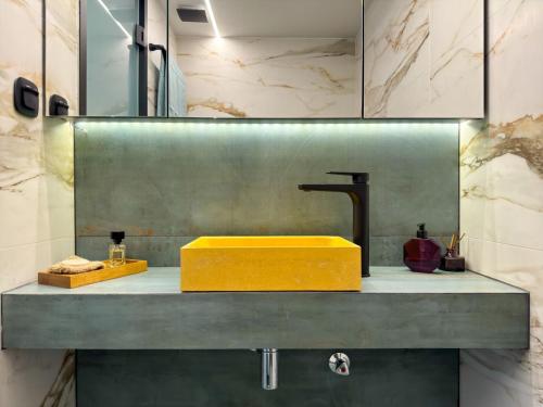 een badkamer met een gele wastafel op een aanrecht bij Aristotelous Luxury Stay in Thessaloniki