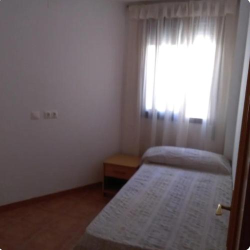 a small bedroom with two beds and a window at Casa Rural Trinquete in Montán