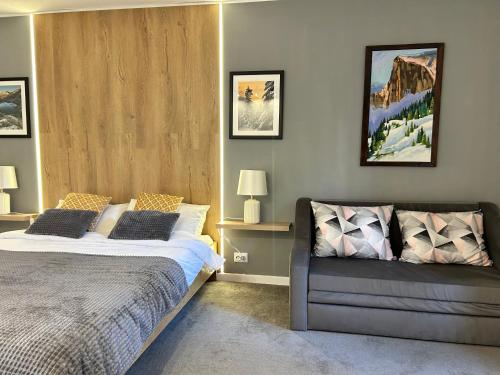 a bedroom with a bed and a couch at Devonshire Lodge Chalet in Bansko