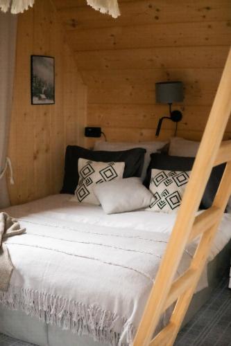 a bedroom with a bed in a log cabin at RELAS - przytulny domek z dwoma sypialniami i antresolą oraz JACUZZI in Murzasichle