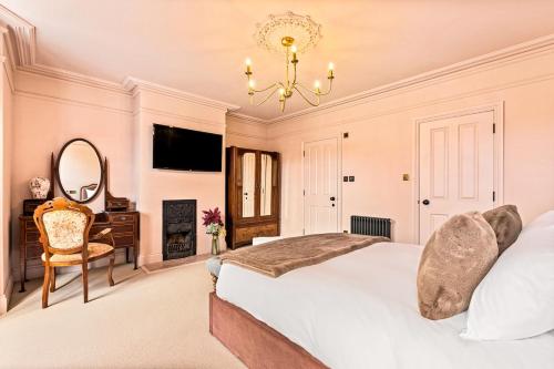 a bedroom with a bed and a desk and a mirror at The Royal Paddock in Ascot