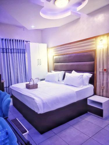 a bedroom with a large bed with white sheets and pillows at UG shortlet apartment in Isagatedo