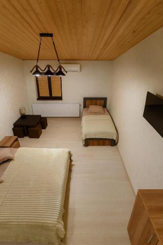 a bedroom with two beds and a chandelier at HOTEL RANCHO UPLISTSIKHE სასტუმრო რანჩო უიფლისციხე in Uplistsikhe