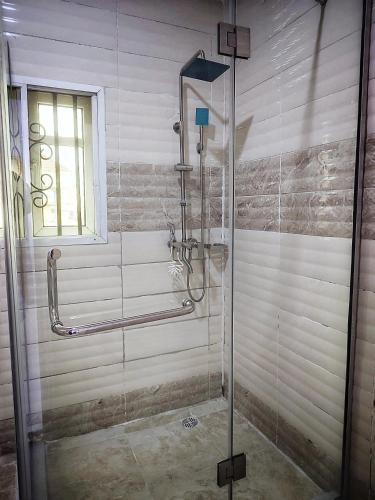 a shower with a glass door in a bathroom at UG shortlet apartment in Isagatedo