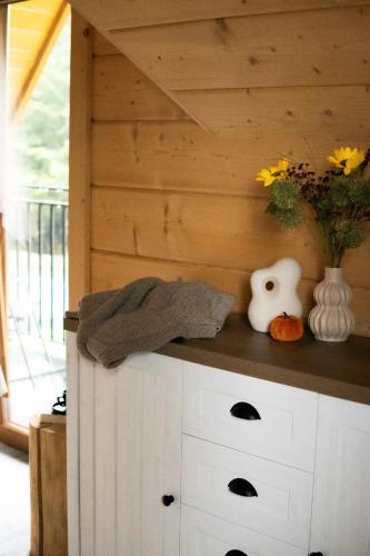 a room with a wooden wall with a counter with a vase at RELAS - przytulny domek z dwoma sypialniami i antresolą oraz JACUZZI in Murzasichle