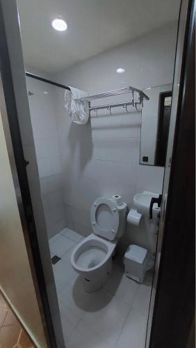 a white bathroom with a toilet and a sink at Hotel Maram in Tangier