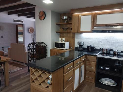 a kitchen with wooden cabinets and a black counter top at Bahía Fragata 204 in San Andrés